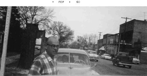 Clayton O. Nordan on Main Street, 1960. Stump of a recently cut tree can be seen over his left shoulder. at right, Masonic building, which housed Times Printing. Next to it is the Western Auto building.